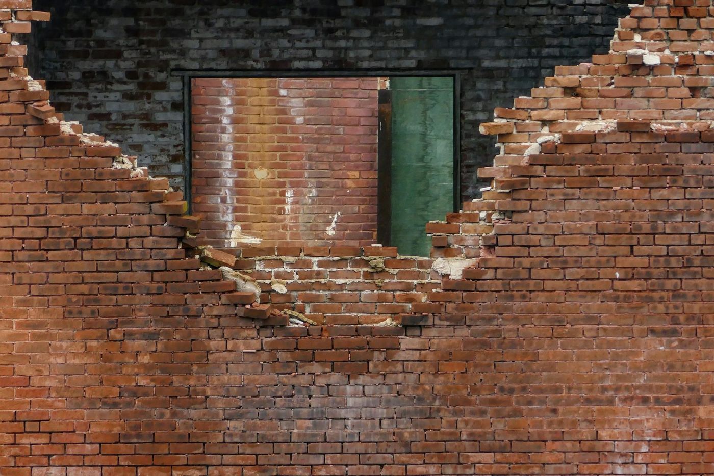 Damaged brick wall being repaired